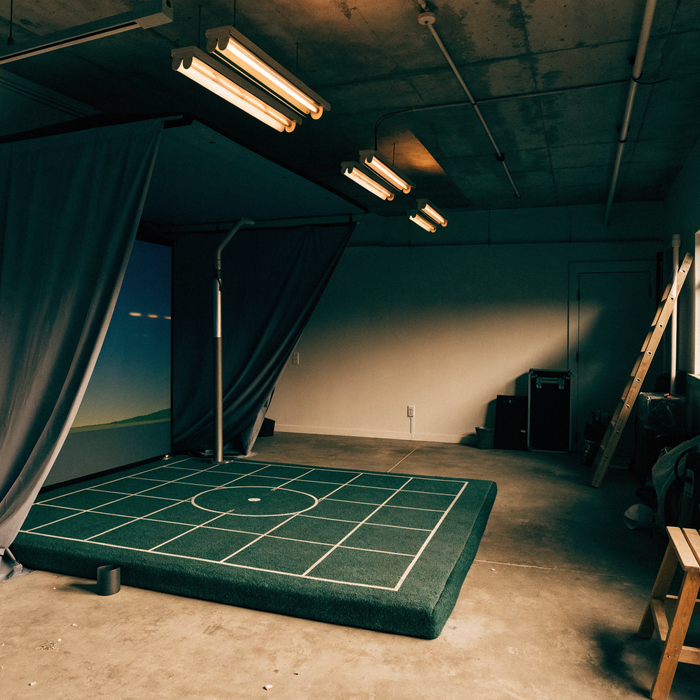 Two-car garage converted into a golf simulator bay with impact screen and side netting