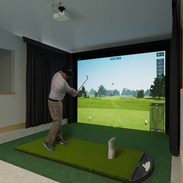 Person playing golf simulation game in a home setting with a screen displaying a golf course.