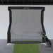 Golf practice net with a golf club on a gray floor and white wall background